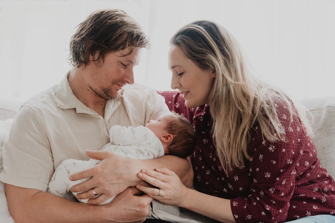 A father and mother holding their newborn baby