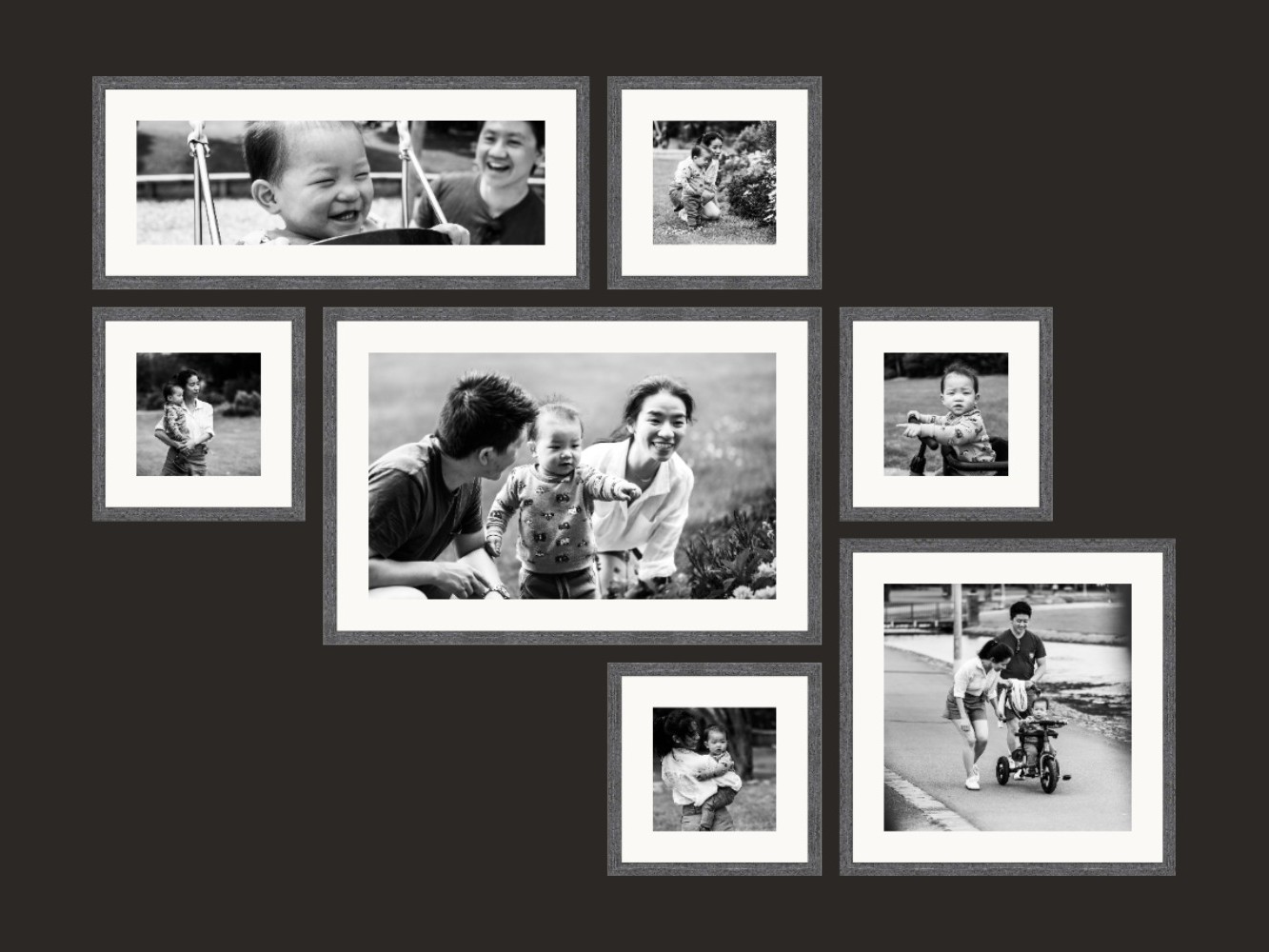 Seven black and white framed prints of a young family, arranged together as one wall collection